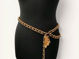 un torse de mannequin noir avec une ceinture en chaîne dorée