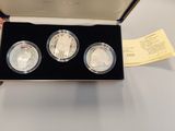 two silver coins in a box with a yellow ticket