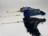 deux parapluies ornés de plumes, posés sur une table