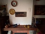 une cheminée dans un coin de la pièce, avec des tableaux accrochés au mur