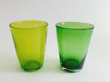 two green glasses sitting next to each other on a table