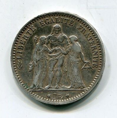 une vieille pièce d'argent sur laquelle figure l'image d'un groupe de personnes