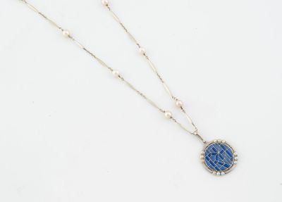 un collier avec un pendentif en pierre bleue monté sur une chaîne en argent