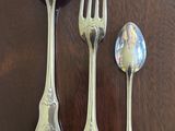 three spoons, a fork and a spoon sitting on a table