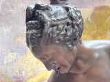 une statue représentant une femme avec un chien sur les genoux