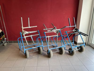 several carts are lined up against a red wall in a room