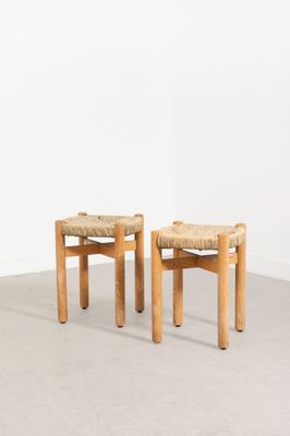 deux tabourets en bois avec des assises tressées dans une pièce vide