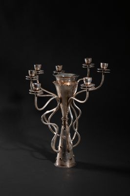 a silver candelier with five candles on a black background