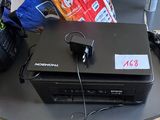 un ordinateur portable posé sur une table, à côté d'un paquet de chips
