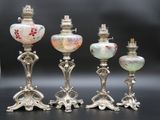 cinq vases en argent et en verre posés les uns à côté des autres sur une table