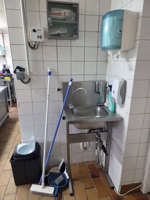 une salle de bains avec un lavabo et une serpillière posée par terre