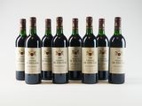 six bottles of wine lined up in a row on a white surface