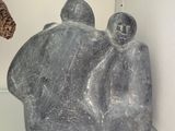 a stone sculpture of a group of people on display in a glass case