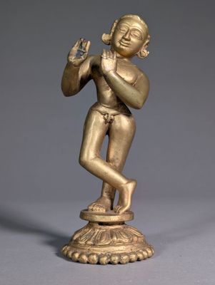 an image of a gold statue of a man playing a flute