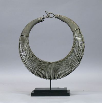 une photo d'un collier en argent posé sur un socle noir