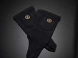 pair of black socks with gold buttons on a black background
