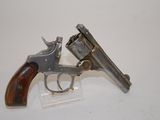 two revolvers sitting on a clear stand on a white surface