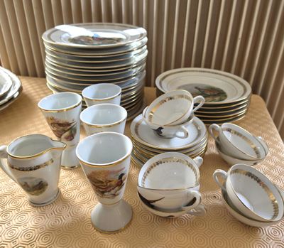 many cups and saucers on a table with a yellow tablecloth