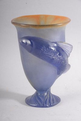 un vase bleu orné d'un poisson, posé sur un fond blanc