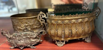 two silver pots sitting on a table next to each other