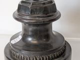 a bronze statue of a woman holding a bird on top of a pedestal