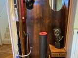 une armoire en bois sur laquelle sont posés un miroir et un chapeau