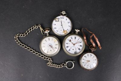 plusieurs types différents de montres de poche attachées à une chaîne, posées sur une surface noire