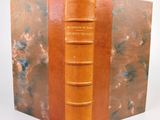 un vieux livre à la couverture marron et à la reliure en cuir marron