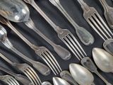 a lot of silver spoons and forks on a table