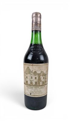 une vieille bouteille de vin posée sur une surface blanche