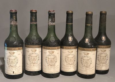 six bottles of wine are lined up in a row on a table