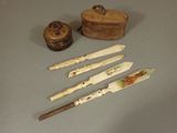 quatre types de couteaux différents et une boîte posée sur la table