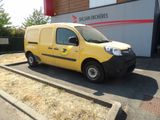 une petite camionnette jaune garée devant un immeuble