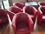six red leather chairs sitting in a circle in front of a table