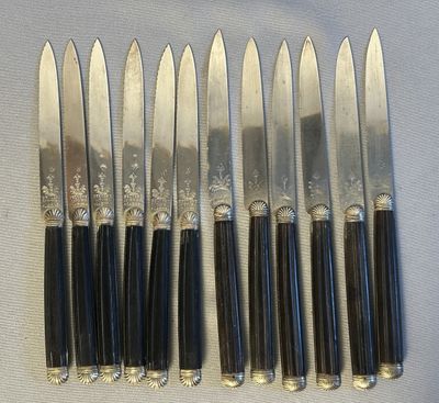 six knives are lined up in a row on a table