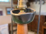 a metal object with a wooden base in a glass case