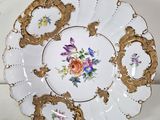 a white plate with gold trim and flowers on it