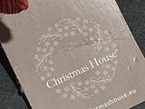 a tag that says christmas house on it next to a teddy bear