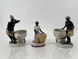 trois figurines représentant un homme et une femme assis sur le bord d'une tasse