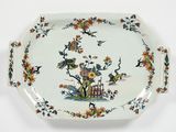 une assiette blanche décorée d'un motif représentant un oiseau et des fleurs