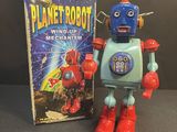 a close up of a toy robot next to a book on a table