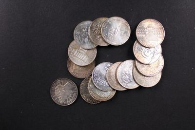 un grand nombre de pièces de monnaie qui se trouvent sur une surface noire