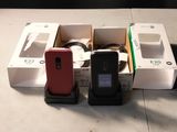 Plusieurs appareils électroniques sont alignés sur une table devant un fond noir.