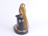 statue of a bird perched on top of a black and gold object