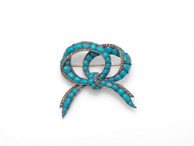 une broche en forme de nœud, en turquoise et diamants