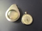 une montre de poche et une loupe posées sur une table