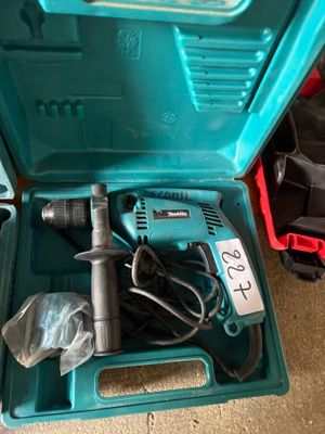 une boîte à outils bleue contenant une perceuse et d'autres outils