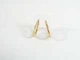 gros plan d'une paire de boucles d'oreilles en or sur une surface blanche