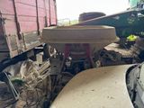 un camion qui trône au milieu d'un tas de ferraille