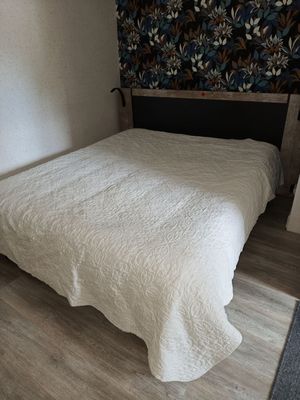 a bed with a white comforter in a small room